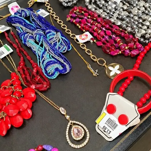 Price tag with a yellow color box next to red jewelry in the showcase at Bargain Thrift Store