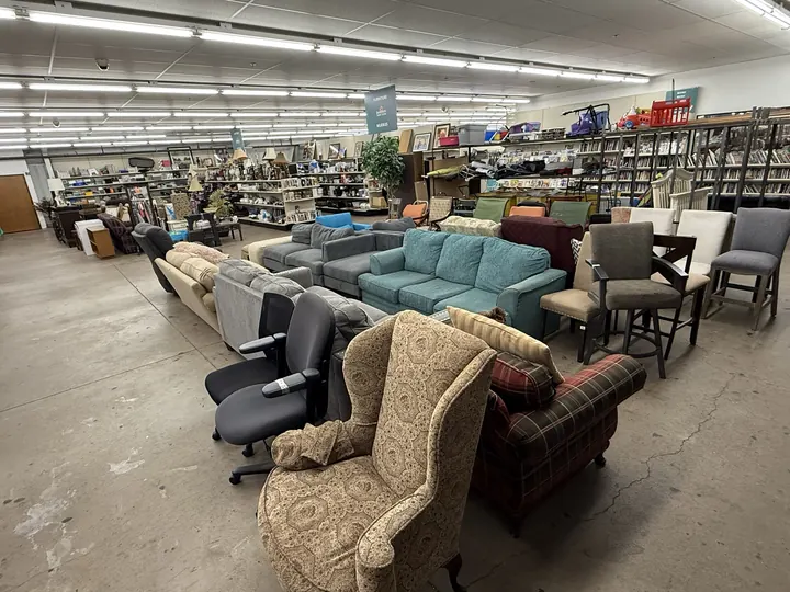 Used sofas, a wingback chair and office chairs on the furniture floor at Bargain Thrift Store in Oklahoma City