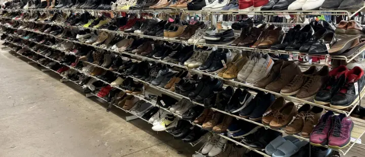 Rows of used shoes on racks at Bargain Thrift Store